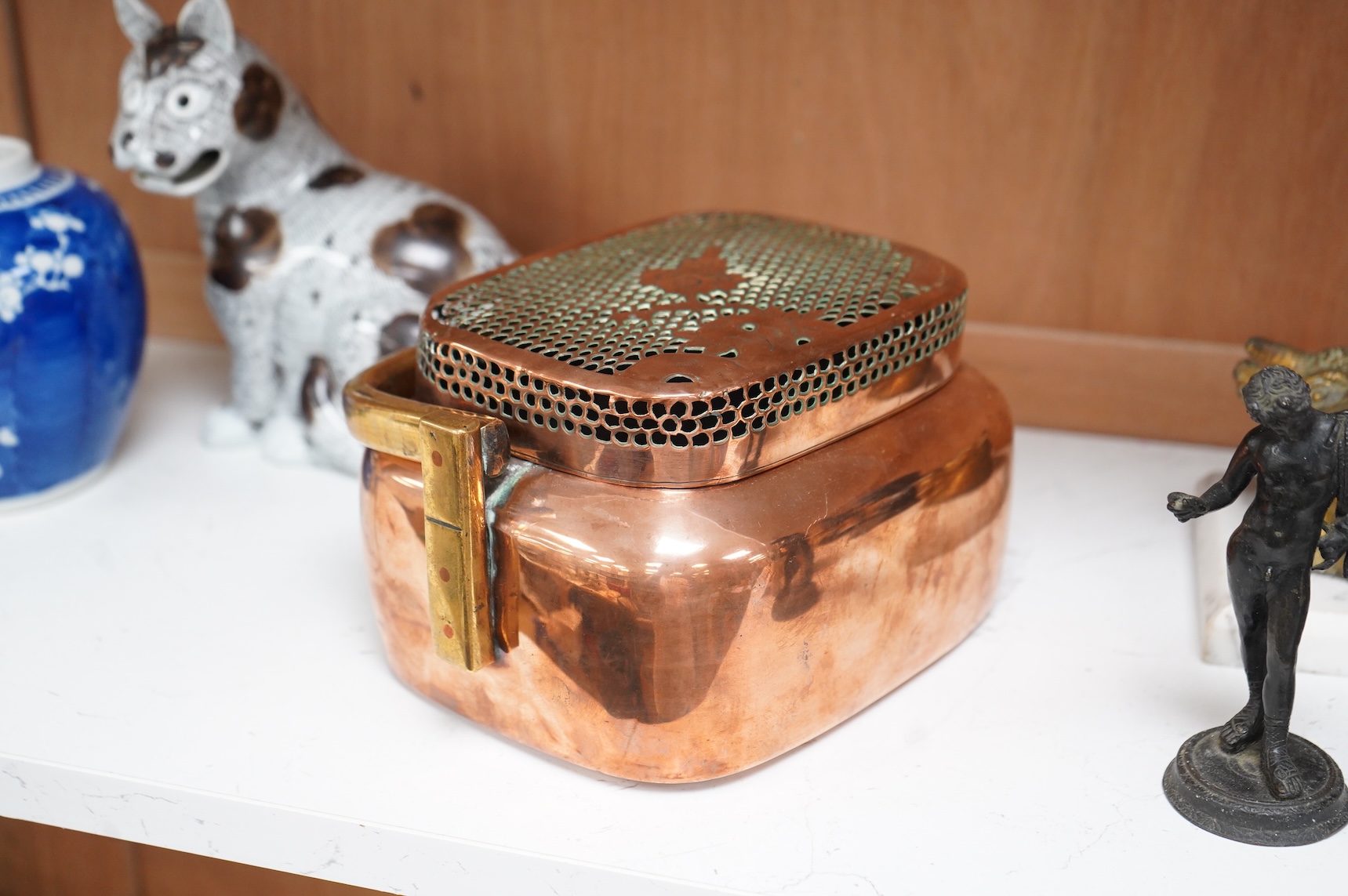 An 18th century Chinese engraved copper handwarmer with brass swing handle, 21cm wide